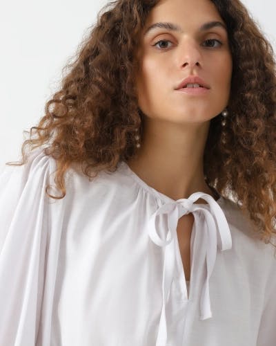 Loose blouse with elastic bands and tie-ups at the neckline